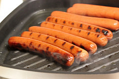 Hot dogs grilling in pan