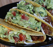 Beef tacos topped with guacamole and lettuce