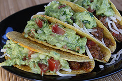 Beef tacos topped with guacamole and lettuce