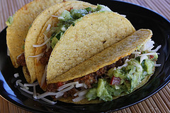 Beef tacos topped with guacamole and lettuce