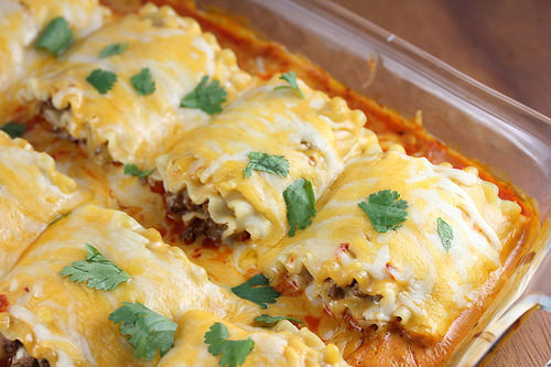 Cheesy taco lasagna roll ups garnished with cilantro