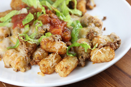 Loaded tater tot nachos with salsa and melted cheese