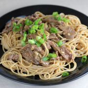 Teriyaki noodles topped with sliced beef and green onions