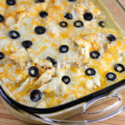 White chicken enchilada bake topped with cheese and black olives