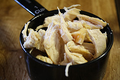 Shredded chicken in black measuring cup