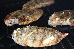 Seasoned chicken breasts grilling on barbecue