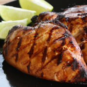 Close up grilled chicken with lime wedges