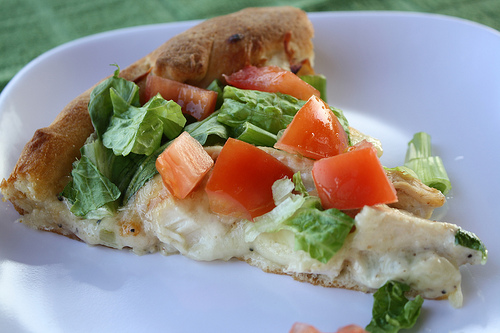 Close up chicken caesar salad pizza slice