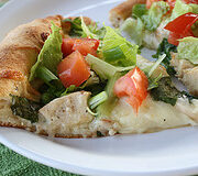 Chicken caesar salad pizza slice on plate