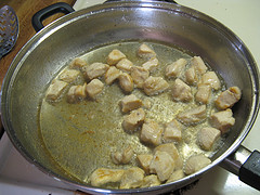 Chicken pieces cooking in pan