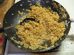 Cooked rice frying in wok