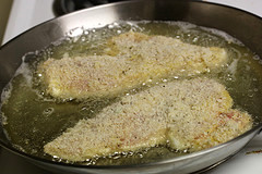 Breaded chicken frying in skillet