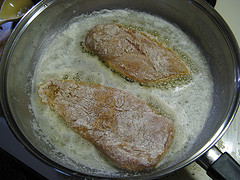 Chicken cutlets frying in pan