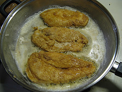 Breaded chicken frying in butter