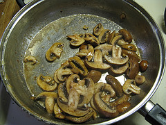 Sliced mushrooms sautéing in pan