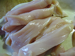 Raw chicken strips on cutting board
