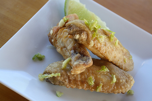 Lime chicken wings with lime wedge