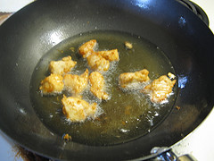 Fried chicken pieces in oil